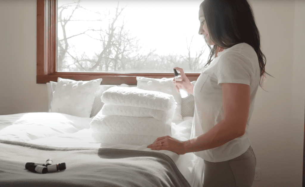 woman using lavender spray on pillows