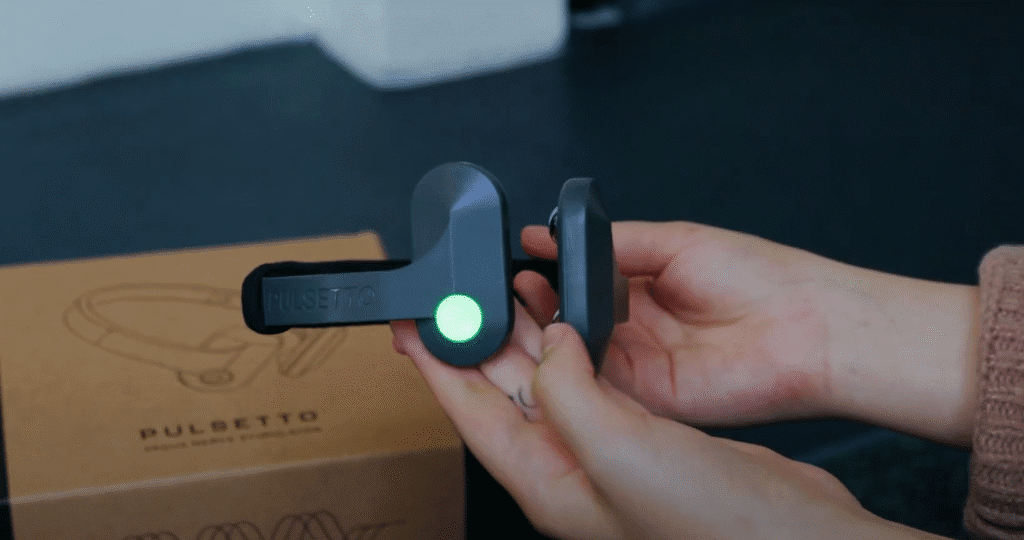 Holding a closeup of the Pulsetto VNS device