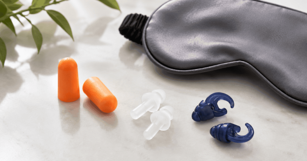 earplugs and sleep earbuds on a table with sleep mask